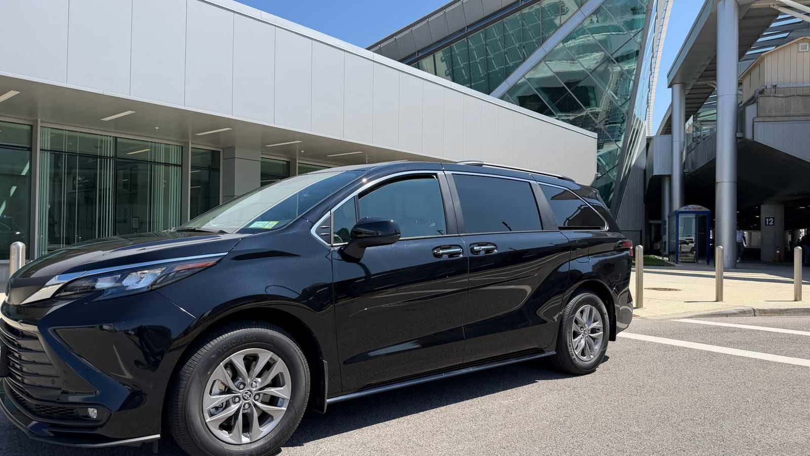 Black Toyota Sienna taxi at the Buffalo Airport pickup lane beside Pole 12