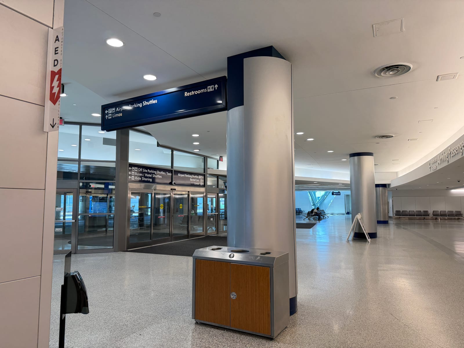 A quiet arrivals hall inside Buffalo Niagara International Airport with the ground transportation exit ahead